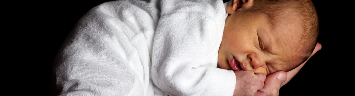 Kleines Baby schläft auf Arm und Hand